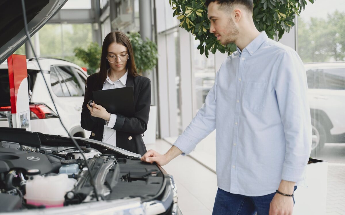 Comprador e vendedor conversando ao lado do carro